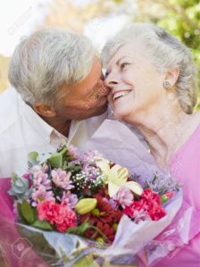 amor matrimonio -el-marido-esposa-flores-dando-besos-al-aire-libre-y-sonriente-foto-de-archivo